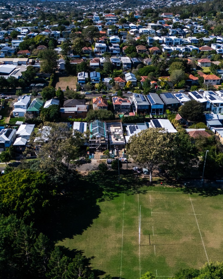 Aerial view over leafy Brisbane streets and a sports oval near the Tarragindi build