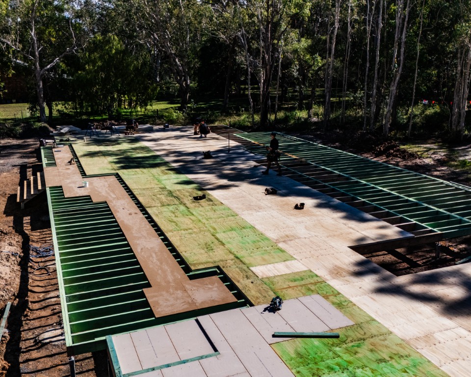 Overhead of a large Platinum "R" Floor going down over green steel joists in a bush setting at Weyba Downs